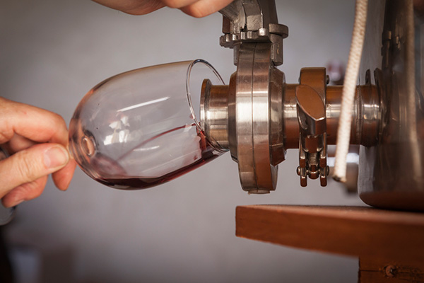 Pour wine from barrel into glass